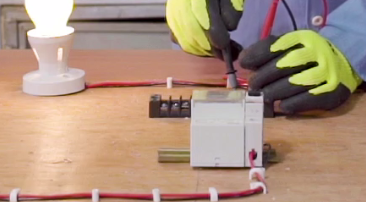Person with safety gloves wiring a switch
